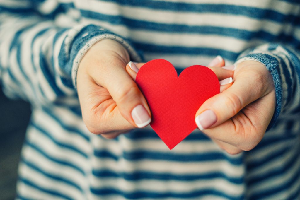 Woman holding red paper heart